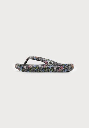 Sort klip-klap sandal med farverigt blomstermønster og cirkulært logo på remmen, vist i sidevisning på ensartet baggrund.