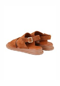 Braune Wildledersandalen mit verstellbarem Schnallenverschluss, offener Zehenpartie, strukturiertem Fußbett und robuster, brauner Gummisohle.