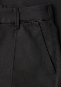 Pantalon noir avec un tissu texturé, une coupe droite, des poches latérales avec des coutures détaillées et une passants de ceinture à la taille.