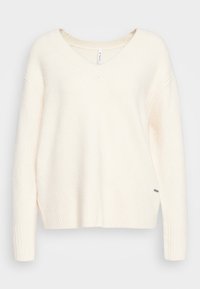 Maglione a V in maglia color crema con bordo e polsini a coste, caratterizzato da una texture morbida e un'etichetta a lato.