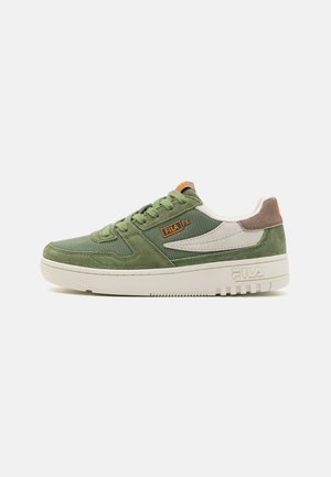 Sneaker verde in suede e mesh con accenti bianchi, caratterizzata da una suola in gomma, punta tonda e branding Fila. Chiusura con lacci e passanti.