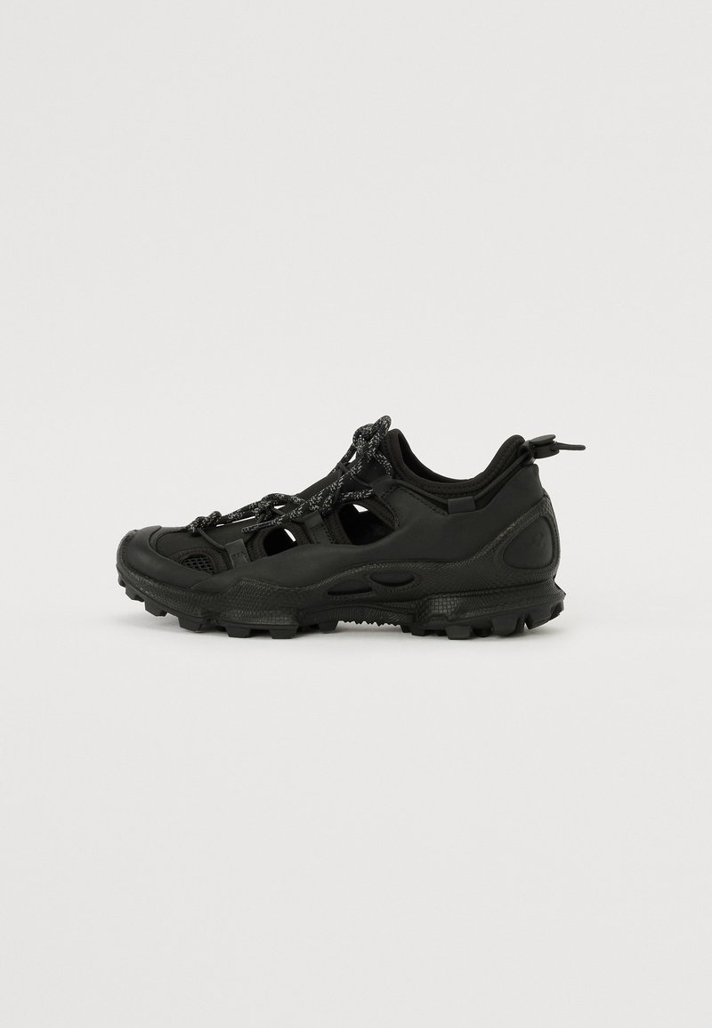 Scarpa da outdoor nera con suola in gomma, tomaia in rete e materiale sintetico, caratterizzata da aree ritagliate, dettagli testurizzati e design con lacci.