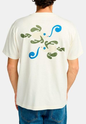 Camiseta de algodón color crema con un diseño abstracto colorido en la parte posterior, con acentos en azul, verde y rojo. Mangas cortas, corte holgado.
