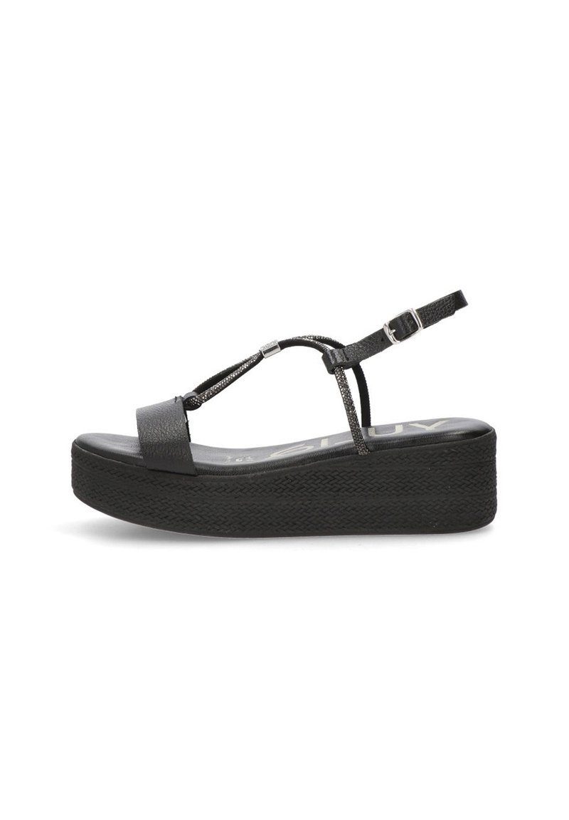 Sandalias de plataforma negras con suela de goma texturizada, diseño de tira en T y hebilla ajustable en el tobillo. Superficie superior lisa con mínimos acentos.