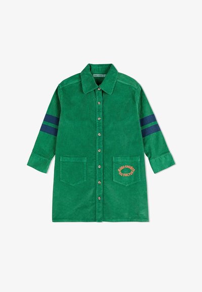 Grünes Kordhemd-Kleid mit zwei Fronttaschen, einem Knopfverschluss und dunkelblauen gestreiften Akzenten an den Ärmeln. Besticktes Logodetail.