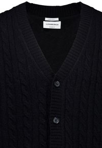 Czarny kardigan z owczej wełny, z dekoltem w serek, wzorem w warkocze, prążkowanym kołnierzem i zapięciem na guziki. Posiada teksturowany materiał i czarne guziki.