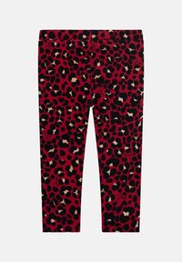 Red leggings with a black and gold leopard print pattern, featuring an elastic waistband and "Guess" logo accents in black.