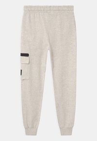Lichtgrijze sweatpants met een elastische tailleband, taps toelopende boorden en een zijzak met zwarte accenten. Gemaakt van zachte, gestructureerde stof.