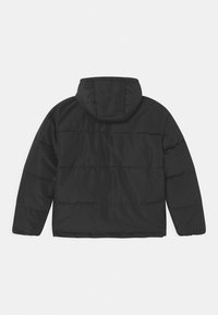 Czarna pikowana kurtka z kapturem, o gładkiej fakturze, z przeszyciami dekoracyjnymi i długimi rękawami. Brak widocznych okuć czy ozdób.