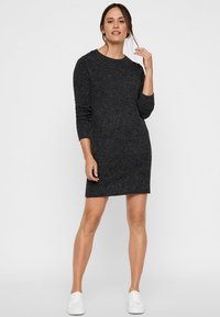 Ciemnoszara sukienka swetrowa, dopasowany krój, okrągły dekolt, długie rękawy, prążkowana faktura na rękawach, połączona z białymi trampkami.