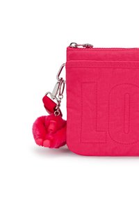 Pink fabric pouch with embossed "LO" lettering, featuring a pink furry monkey charm and silver hardware with a clip attachment.