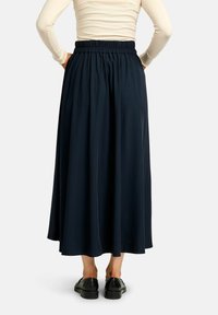 Tengerészkék maxiszoknya elasztikus derékpánttal, pliszírozott mintával és könnyű anyagból, sima textúrával és bokáig érő hosszúsággal.