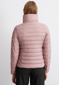 Lyserød puffy jakke med høj krave, med vandret syninger og en figursyet talje. Materialet virker glat og lidt skinnende.