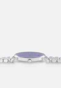 Orologio da polso argento con cassa sottile, quadrante viola e indicatori delle ore minimalisti. Presenta un bracciale in acciaio inossidabile e una corona laterale.