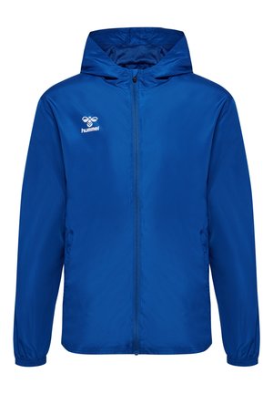 Veste coupe-vent bleue avec fermeture éclair sur le devant, capuche ajustable, poignets élastiques et logo sur la poitrine gauche. Matière lisse et légère.