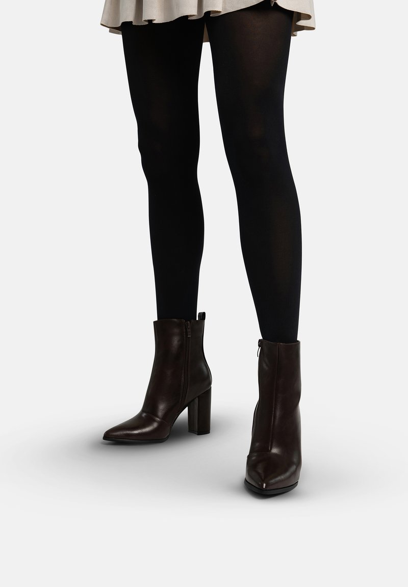 Bruine leren enkellaarsjes met een puntige neus en blokhak. Voorzien van een ritssluiting aan de zijkant en een gladde, gepolijste textuur.