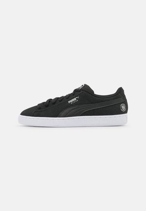 Black suede sneakers with a white rubber sole, featuring rounded toe, tonal laces, and a Puma logo on the side for branding.