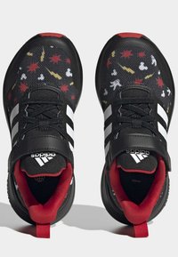 Scarpe sportive nere con una tomaia texturizzata, caratterizzate da motivi colorati, strisce bianche e accenti rossi sul tallone e sulla fodera interna.