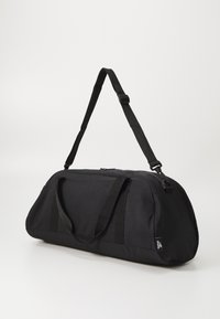 Bolso de deporte negro hecho de tela duradera con asas dobles, correa ajustable y parte superior con cremallera. Textura suave, forma redondeada.