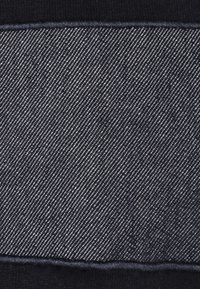 Tessuto denim di un blu navy scuro con una trama a righe diagonali. Il materiale presenta delicate cuciture bianche e un bordo pulito e rifinito.