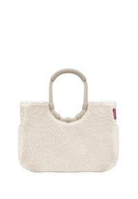 Cremfarbene Tasche aus weichem, strukturiertem Material, mit einem runden Griff und rechteckiger Form. Enthält ein rotes Logoschild.