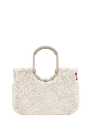 Crème-kleurige tas gemaakt van zacht, textuurmateriaal, met een ronde handgreep en een rechthoekige vorm. Inclusief een rood logo-label.