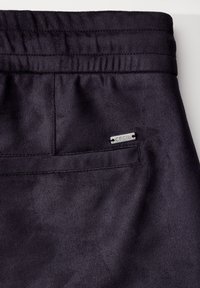 Zwarte zachte stofbroek met een elastische tailleband, voorzien van een achterzak en een zilveren "Cecil" label aan de zijkant. Glad textuur.