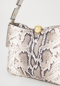 Sac à main en cuir embossé python dans des tons crème et gris. Équipé d'une fermeture à pression dorée et d'une silhouette élégante et courbe. Bandoulière réglable.