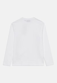 Langärmliges, weißes Baumwoll-T-Shirt mit Rundhalsausschnitt und schlichter Rückseite, mit geradem, leicht lockeren Schnitt am Saum.