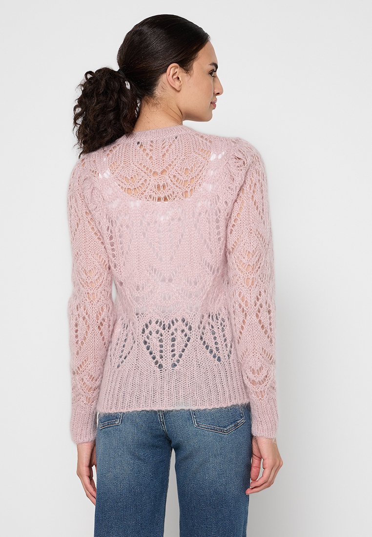 Jasnoróżowy sweter dziany z ażurowymi wzorami, długimi rękawami i dopasowanym krojem. Z tyłu znajduje się szczegółowy motyw serca i ażurowa tekstura.