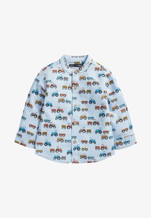 Camiseta de niño pequeña azul claro con mangas largas, botones de madera y un patrón de tractores y remolques coloridos.