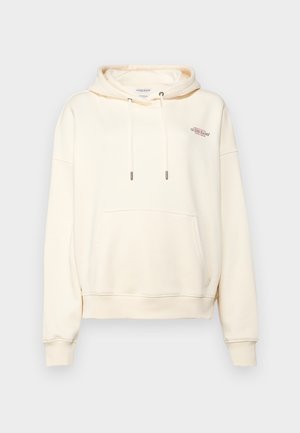 Hoodica boje kreme napravljena od mekanog materijala, s prednjim kengurskim džepom, vezicama sa metalnim završecima i malim izvezenim logotipom.