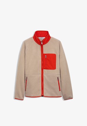 Veste en polaire beige avec des accents rouges, dotée d'un col haut, d'une poche poitrine zippée et de deux poches latérales zippées.