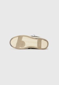 Grønnmønstret såle til sneakers med en kremfarget gummibunn med tekstur, som har et sirkulært logo og sikksakk-mønster for godt grep.