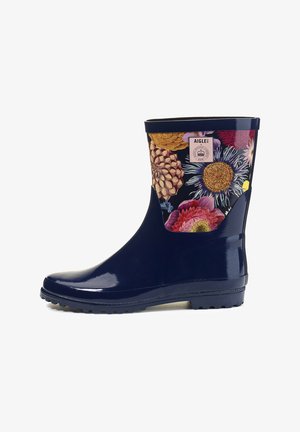 Botte en caoutchouc marine présentant une tige à motif floral avec des couleurs et textures vives. Accent logo sur le côté et semelle texturée pour une meilleure adhérence.