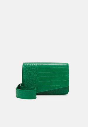 Grøn rektangulær crossbody taske med krokodille tekstur og matchende rem på en ensfarvet lys grå baggrund.