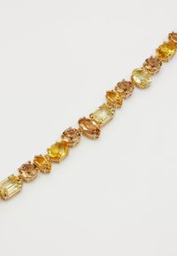 Gold bracelet with alternating yellow, amber, and light brown faceted gemstones in various oval and rectangular shapes.