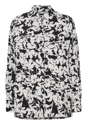 Blouse florale noir et blanc à manches longues, avec un devant boutonné, un col, et un tissu texturé présentant un motif audacieux et contrasté.