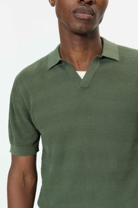 Zelené polo tričko s texturou a výstřihem do V, se vzorem horizontálních pruhů a krátkými rukávy, vyrobené z měkkého pleteného materiálu.