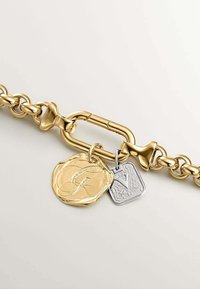 Pulsera de cadena de oro con un diseño de eslabones pulidos, acentuada con dos colgantes: un medallón dorado brillante y una etiqueta rectangular de plata.