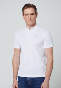 White short-sleeve polo shirt made of smooth cotton, featuring a three-button placket and a subtle embroidered logo on the left chest.