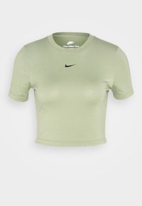 Světle zelené zkrácené tričko vyrobené z hladkého materiálu. Má krátké rukávy a černé logo Nike na hrudi. Jednoduchý, čistý design.