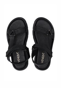 Schwarze Sandalen mit strukturiertem Finish, die mehrere Riemen, eine flache Sohle und Akzente in Goldfarbe aufweisen. Logo auf der Innensohle angezeigt.