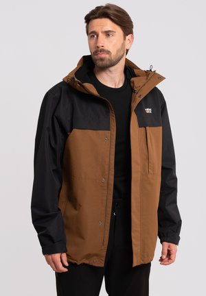 Chaqueta impermeable marrón y negra con capucha, botones a presión, bolsillo frontal y un corte moderno. Textura suave, colores contrastantes y detalle del logo.