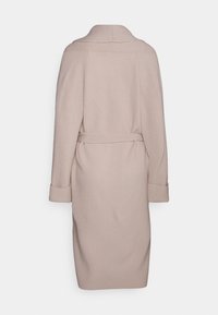 Jasnobeżowy płaszcz o prążkowanej strukturze, z kołnierzem do złożenia, paskiem w talii i podwijanymi mankietami. Charakteryzuje się średnią długością i prostym krojem.