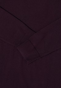 Fioletowy sweter z długim rękawem, z prążkowanymi mankietami i dołem. Wykonany z miękkiego, teksturowanego materiału. Posiada klasyczny okrągły dekolt.