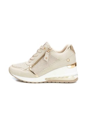 Zapatilla de cuña para mujer en beige y dorado con cordones, cremallera lateral, paneles de malla y suela transparente con amortiguación de aire.