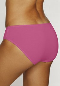 Rózsaszín bikini alsórész sima textúrával és rugalmas derékkal. A dizájn egyszerű, teljes hátsó takarást biztosít.