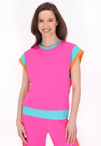 Kortærmet atletisk top i lys pink med turkise og orange detaljer, der har en afslappet pasform og et glat, let materiale.
