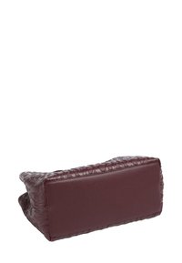 Bolso de cuero burdeos con una superficie texturizada, que presenta una base rectangular lisa y bordes suaves y redondeados.